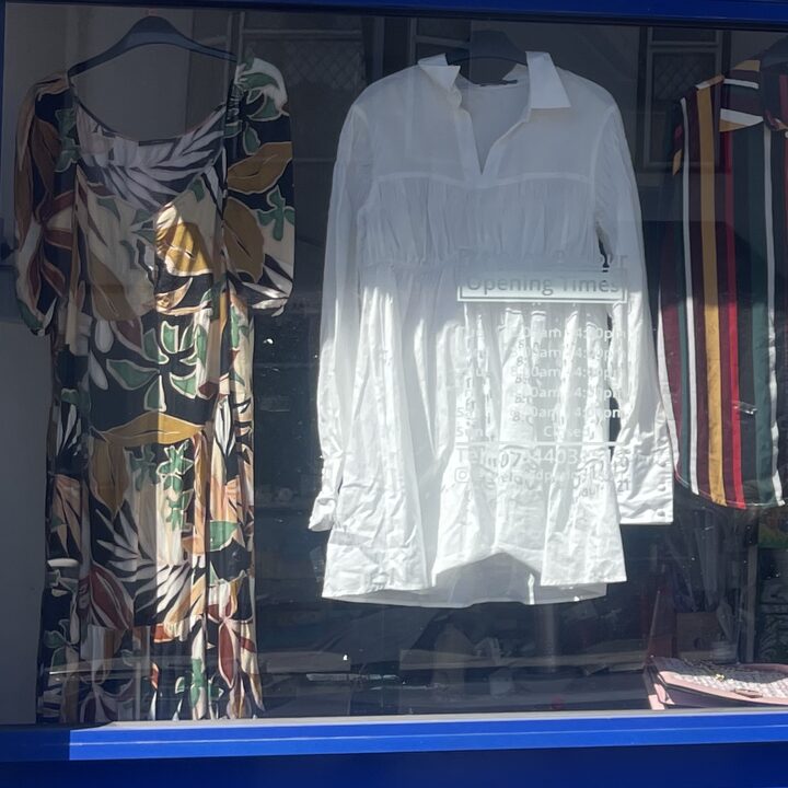 A patterned floral dress beside a white tiered cotton blouse
