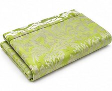 A folded green throw with a floral pattern